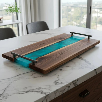 Live edge black walnut charcuterie board with deep teal epoxy river and matte black handles, polished finish