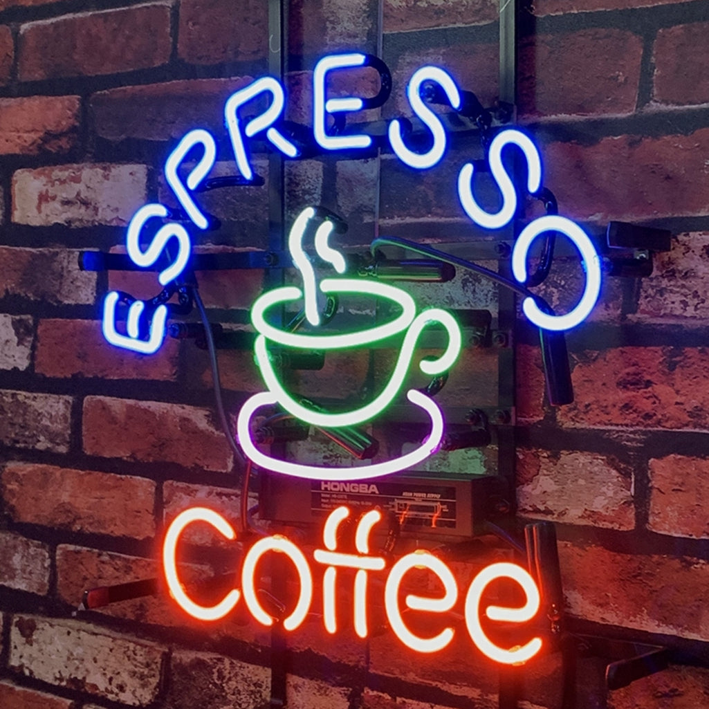 Curved blue neon text "ESPRESSO" above a green and white neon steaming coffee cup, with red neon "coffee" below, mounted on a brick wall.