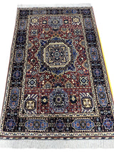 Rectangular hand-knotted Afghani Mamluk wool rug with intricate geometric and floral motifs in blue, brown, cream, and black, featuring a central medallion and fringed edges.