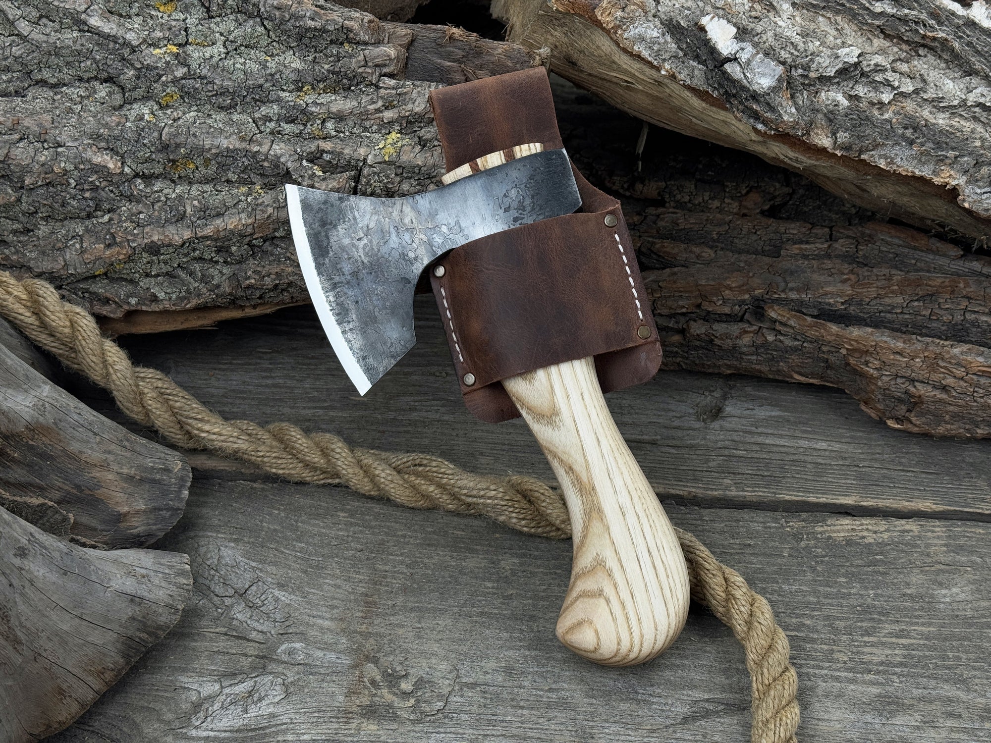 Small carving axe with carbon steel blade and ash wood handle, featuring leather sheath with belt loop