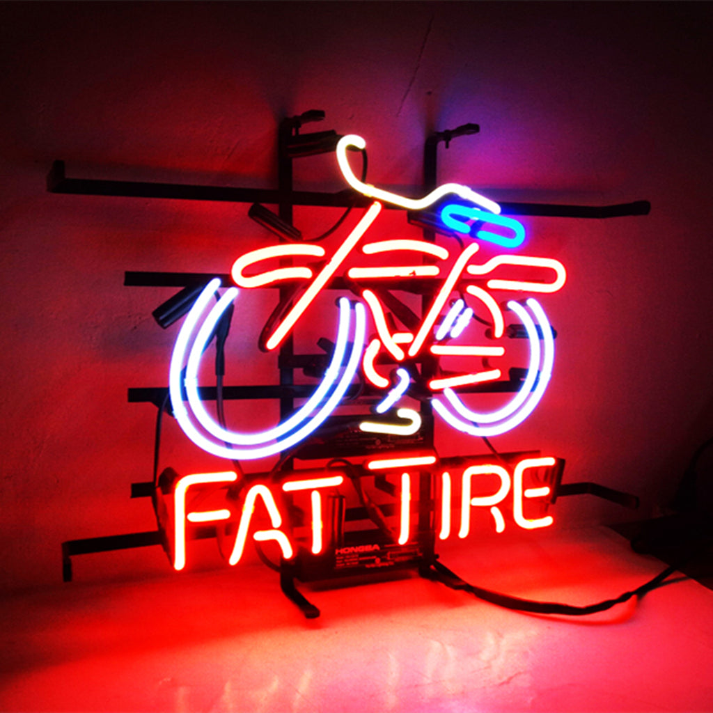 Neon sign depicting a red fat tire bicycle with a blue handlebar and white tire outlines above the glowing red text 'FAT TIRE' on a black metal frame.
