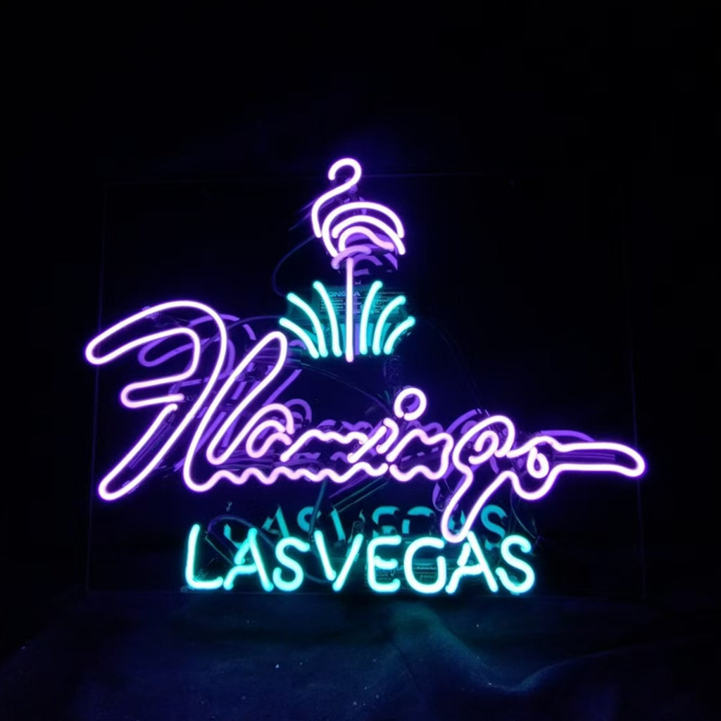 Neon sign featuring a purple flamingo above the word 'Flamingo' in purple script and 'LAS VEGAS' in blue block letters on black background.
