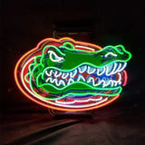 Neon sign depicting a green alligator head with white teeth outlined in bright orange and red against a black background.