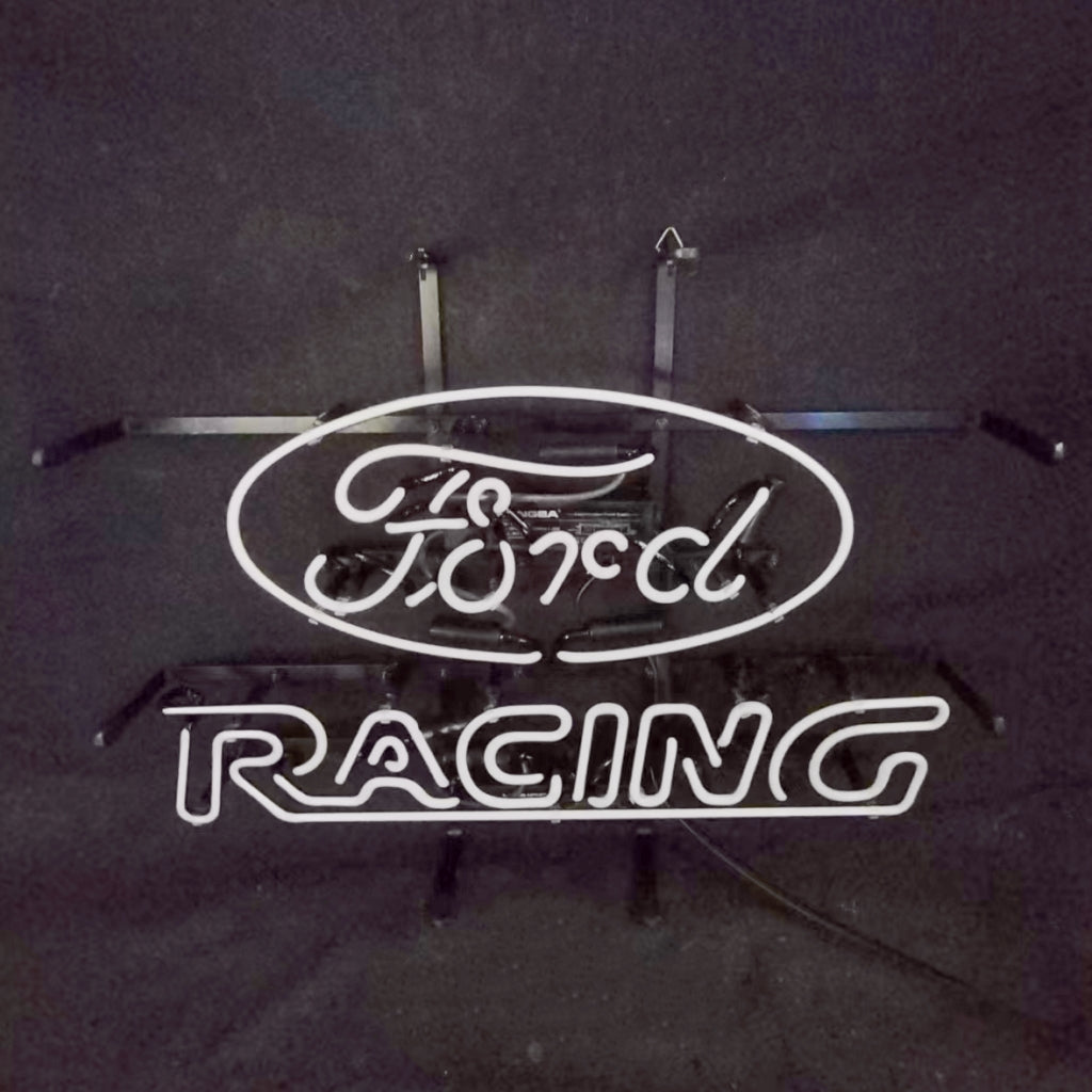 White neon sign displaying 'Ford' in cursive inside an oval above the word 'RACING' in block letters on a dark background with visible mounting brackets.