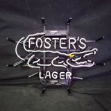 White neon sign depicting a stylized alligator outline with 'FOSTER'S' inside and 'LAGER' below on a black metal frame against a dark background.