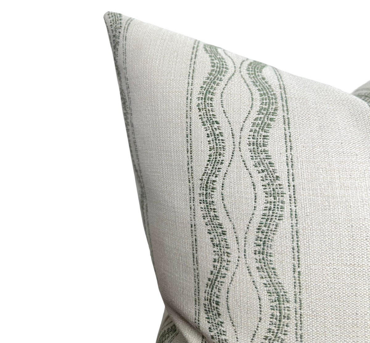 Close-up of beige outdoor pillow cover with vertical moss green wavy and dotted stripes, showing fabric texture and clean stitching at the corner.