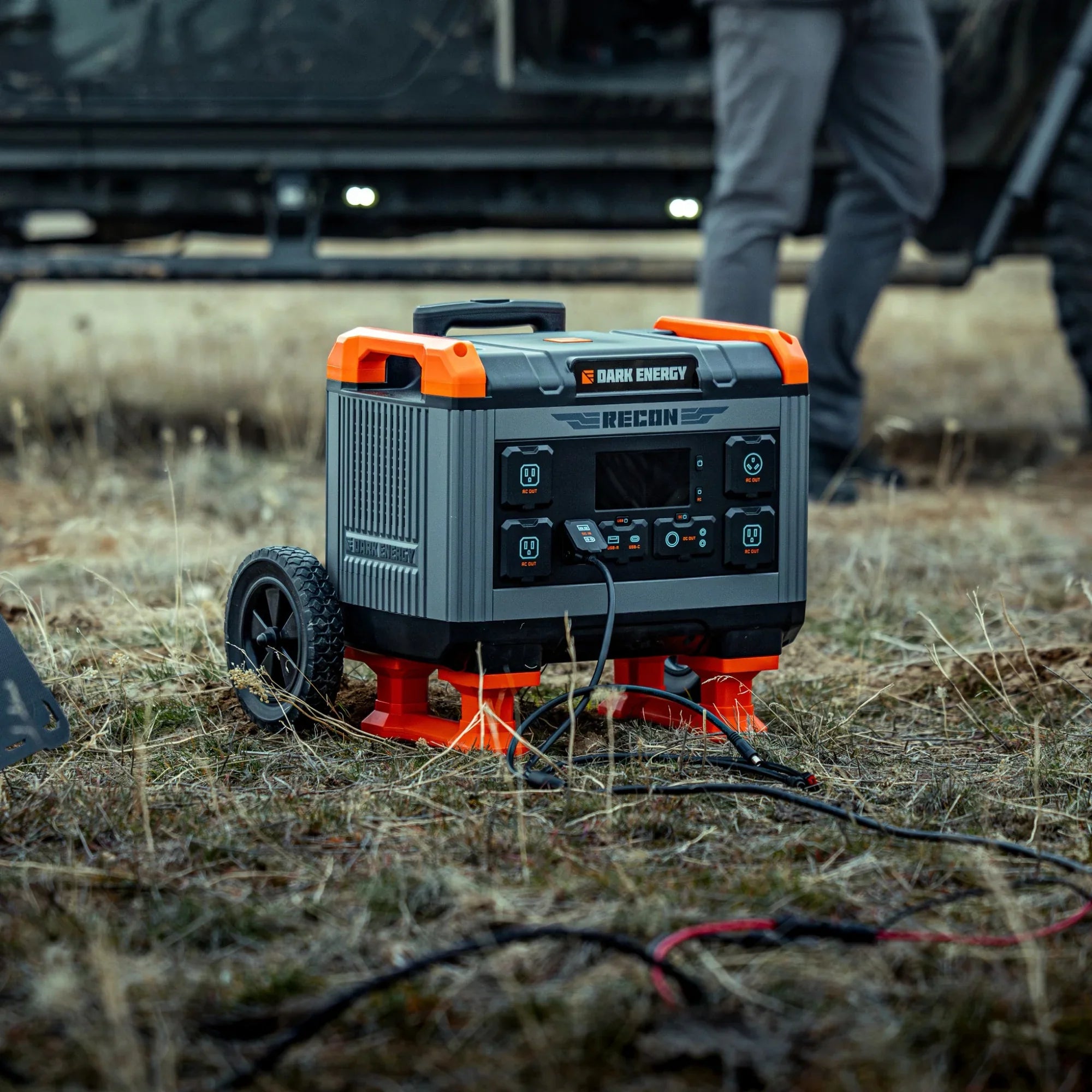 Recon 2000 Power Station on outdoor terrain showing reinforced aluminum shell, telescoping handle, and rugged wheels