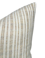 Close-up of a pillow cover with narrow vertical stripes in beige and off-white woven fabric, showing a textured pattern and a pointed corner.