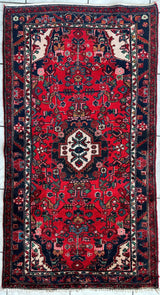 Vintage Persian Hamadan rug featuring geometric patterns in muted tones, laid flat in natural light.