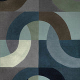 Square textile pillow cover with abstract curved shapes in indigo, gray, green, and brown forming a geometric pattern of connected arches.