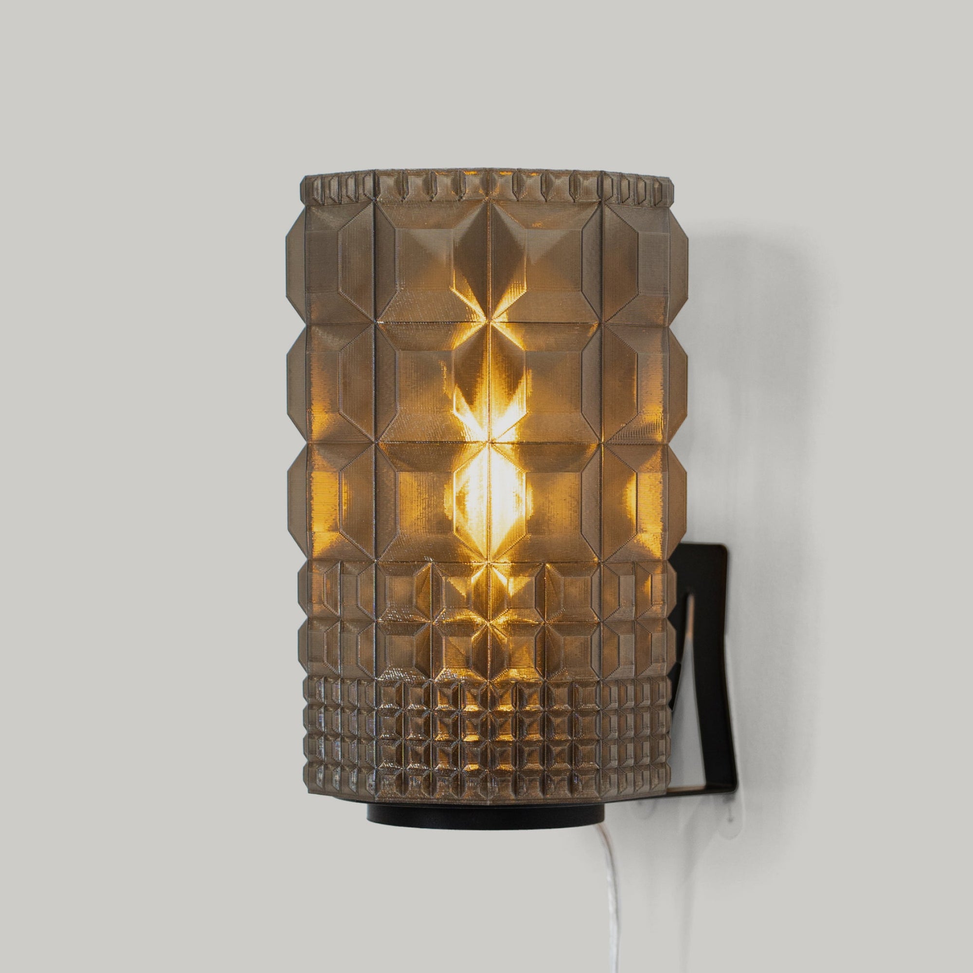 Gem Sconce wall light lit against a dark wall showing geometric shapes