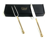 Set of two stainless steel carving tools, a fork and a knife, with gold-toned textured handles placed beside a black box labeled Vibsha.