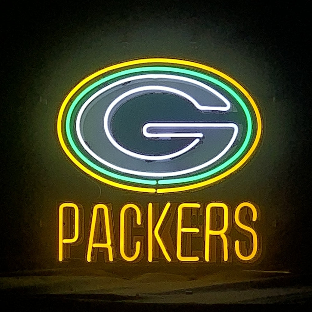 Neon sign of Green Bay Packers logo with a white 'G' inside green and yellow oval, and yellow text 'PACKERS' below, glowing brightly against a dark background.