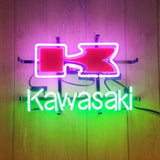 Neon sign featuring a large red stylized 'K' outlined in pink above the word 'Kawasaki' in bright green on a wooden wall background.