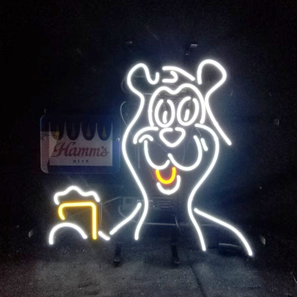 Neon light sign of a smiling bear holding a frothy beer mug, outlined in white and yellow neon tubes against a dark background with a Hamm's Beer logo in the corner.