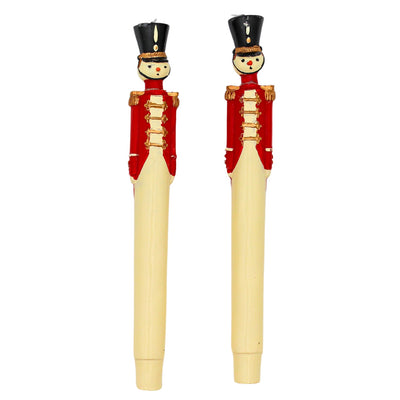 Two handpainted red royal guard candles with navy blue coat, gold trim, and black detail displayed upright on a white surface.
