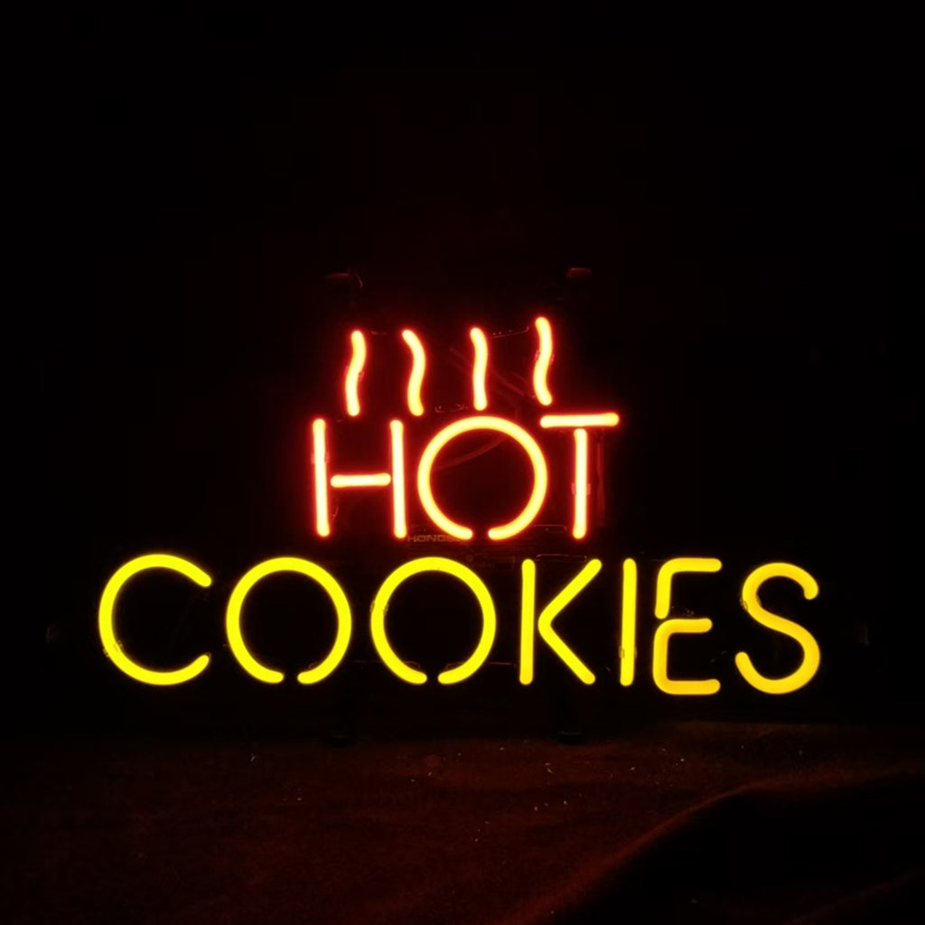 Neon sign with the word HOT in red with three wavy lines above it, and COOKIES in yellow below on a dark background.