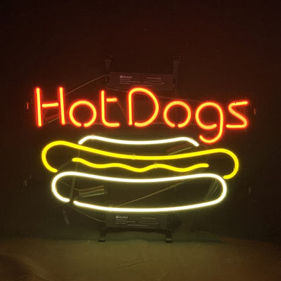 Hot Dogs Neon Sign illuminated in red and yellow, mounted on a metal grid backing