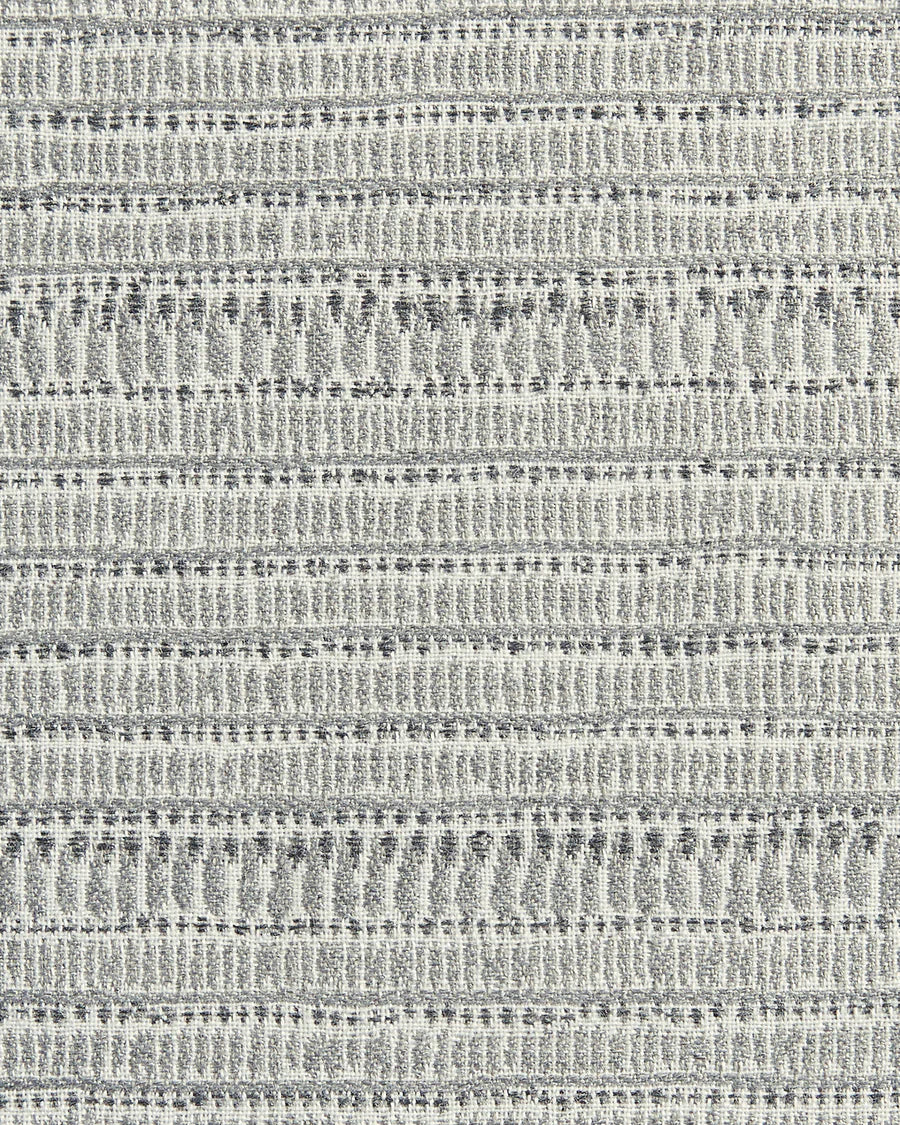 Textured woven pillow cover with horizontal rows of small geometric and linear patterns in varying shades of soft gray and off-white tones.