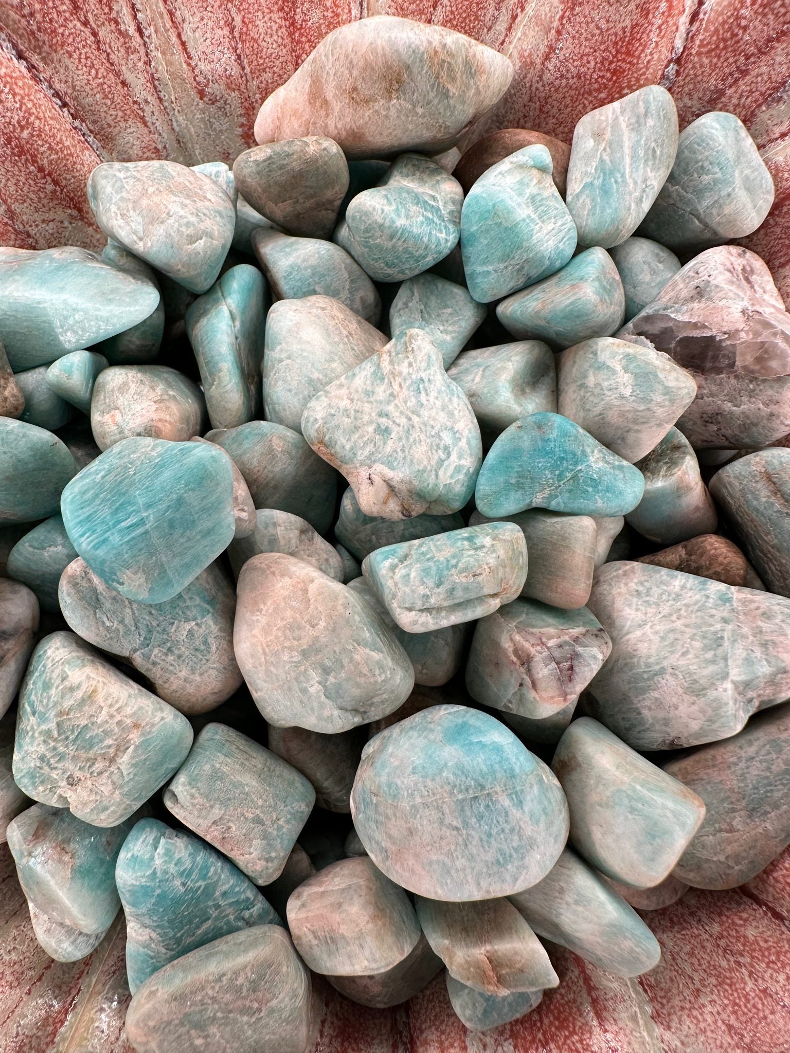 Raw tumbled Larimar stones in varying sizes for jewelry and crafts