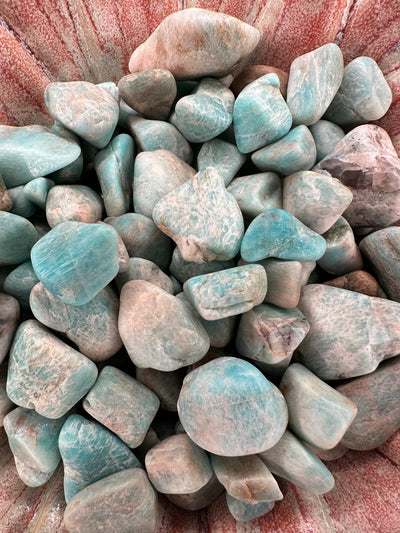 Raw tumbled Larimar stones in varying sizes for jewelry and crafts