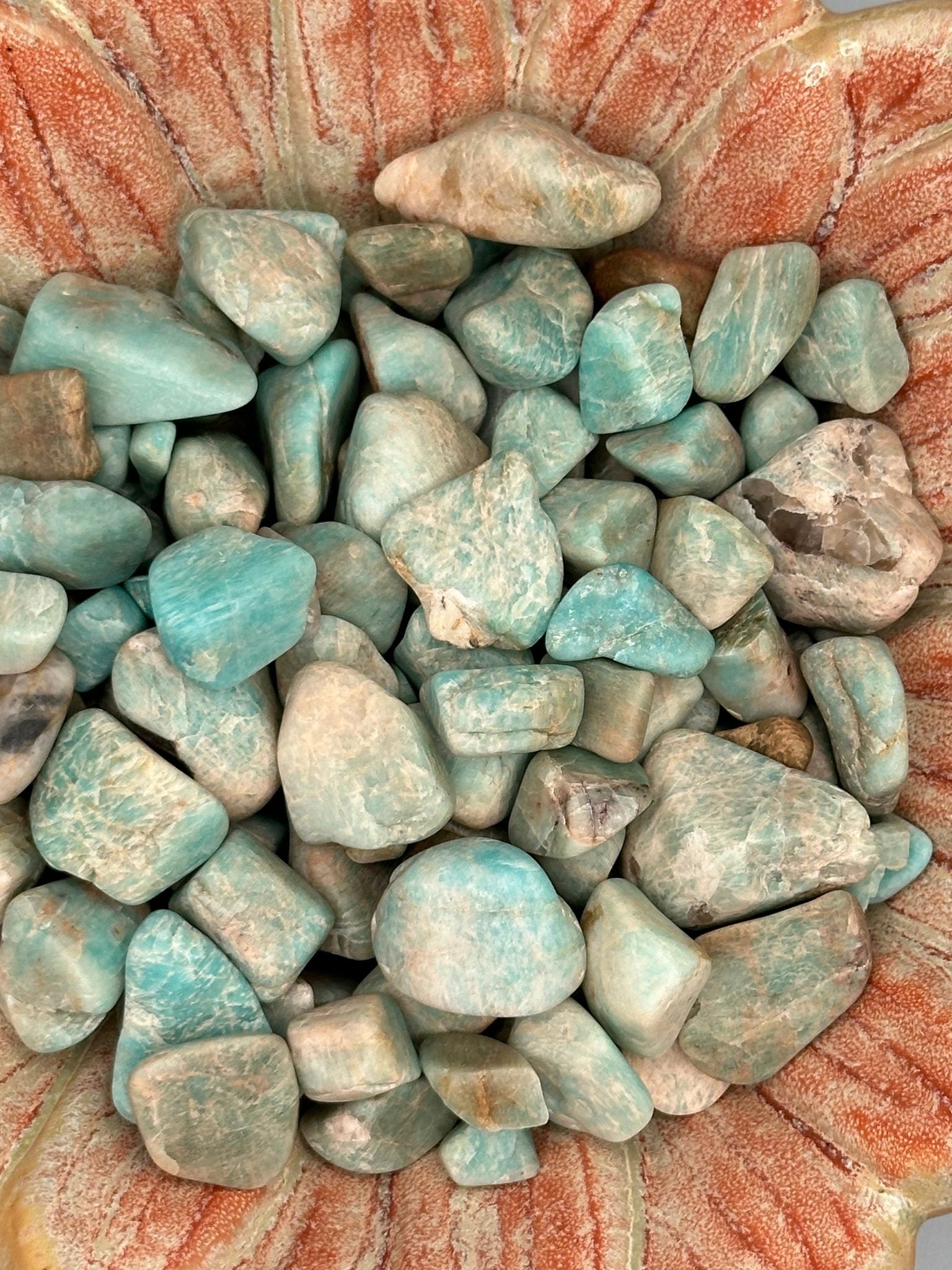 Raw tumbled Larimar stones in varying sizes for jewelry and crafts