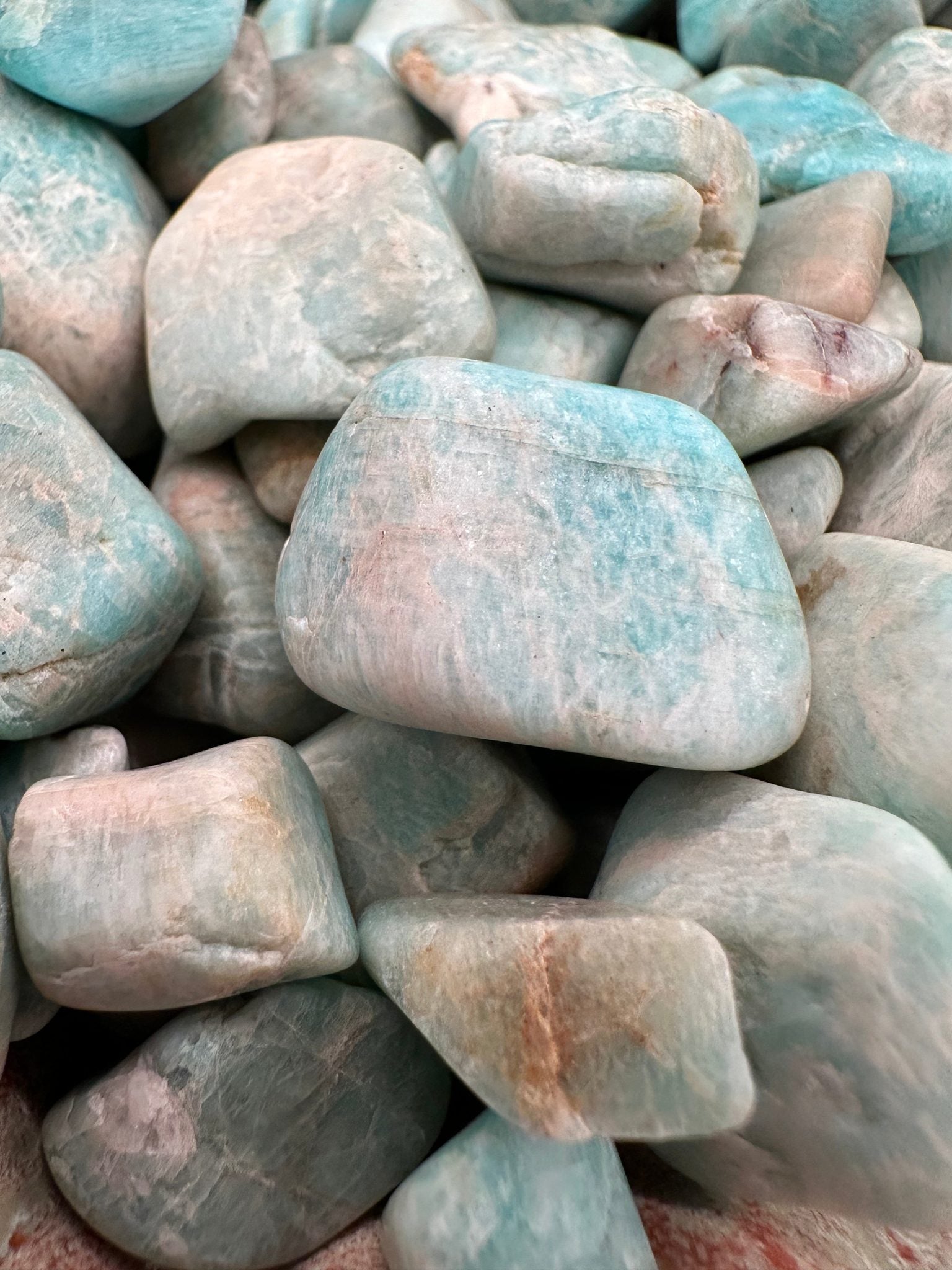 Raw tumbled Larimar stones in varying sizes for jewelry and crafts