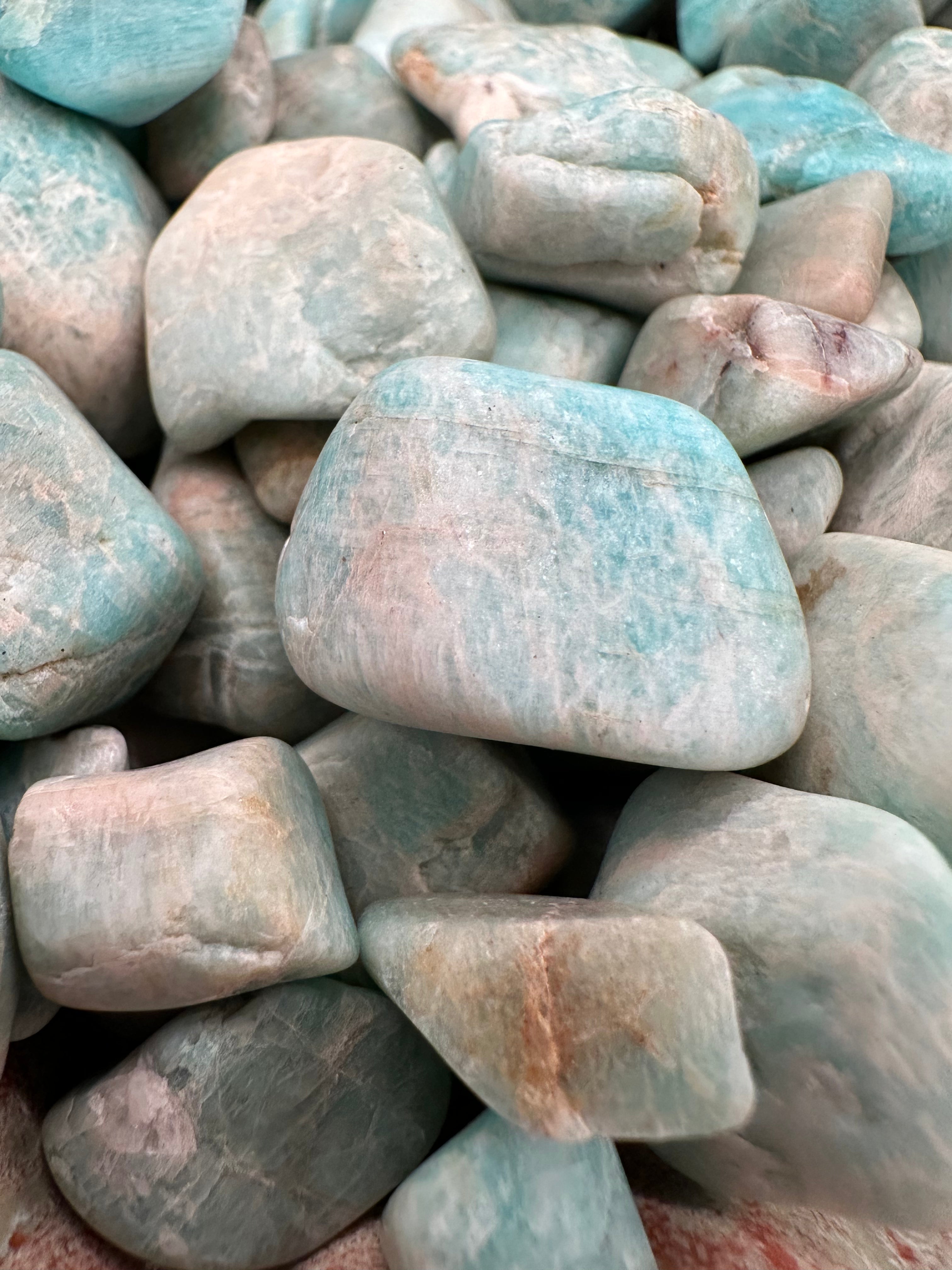 Raw tumbled Larimar stones in varying sizes for jewelry and crafts