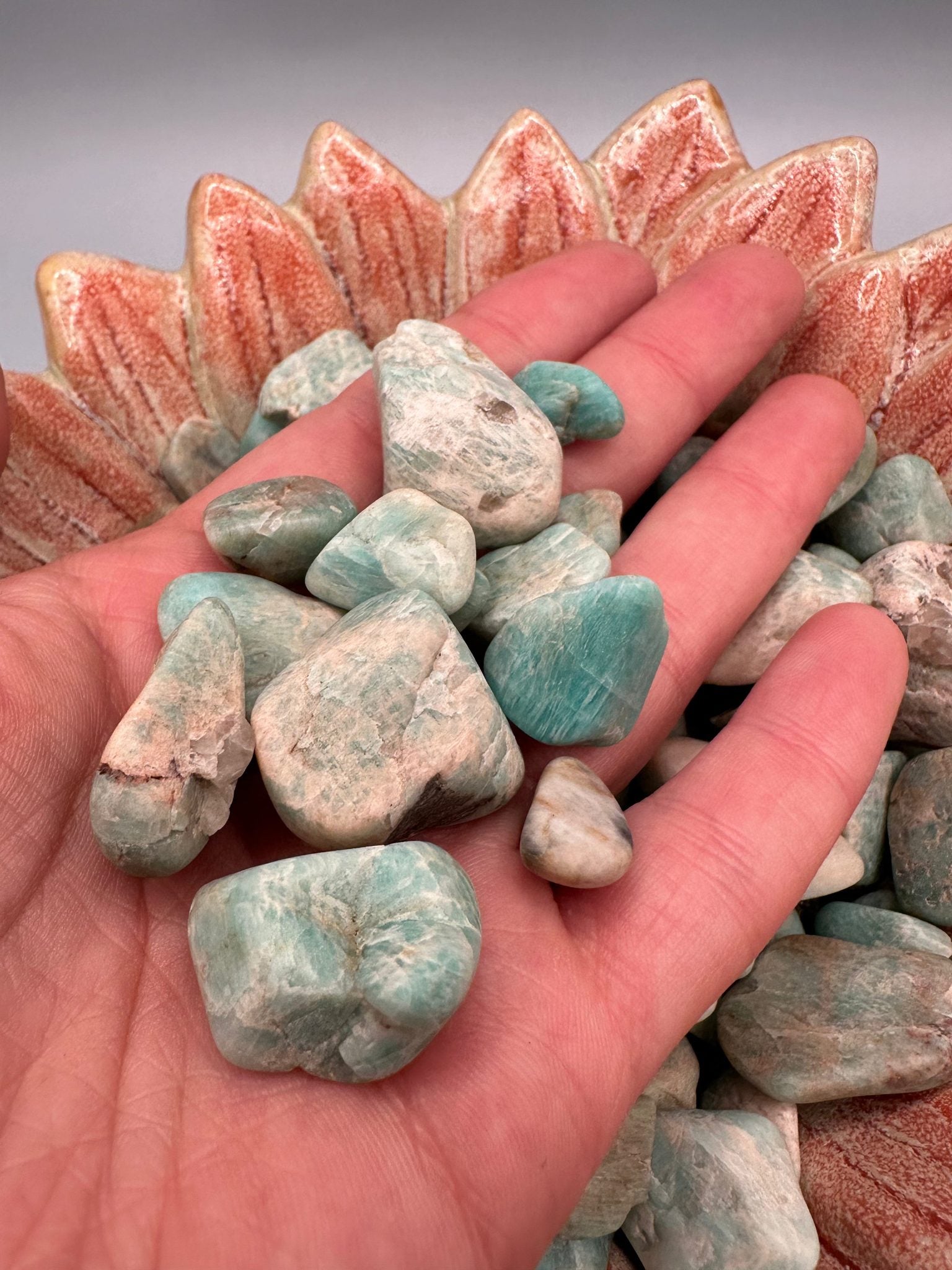 Raw tumbled Larimar stones in varying sizes for jewelry and crafts