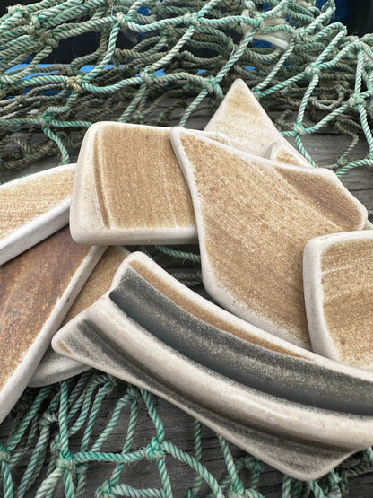 Assorted hand-tumbled pottery pieces in earthy colors for mosaic crafts