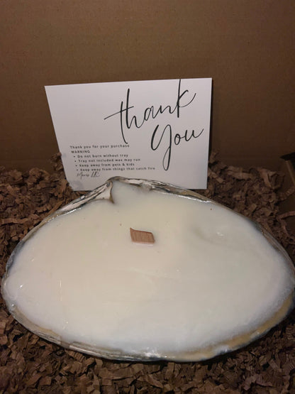 Limited edition candle in a dark, weathered quahog shell from December 2025 storm