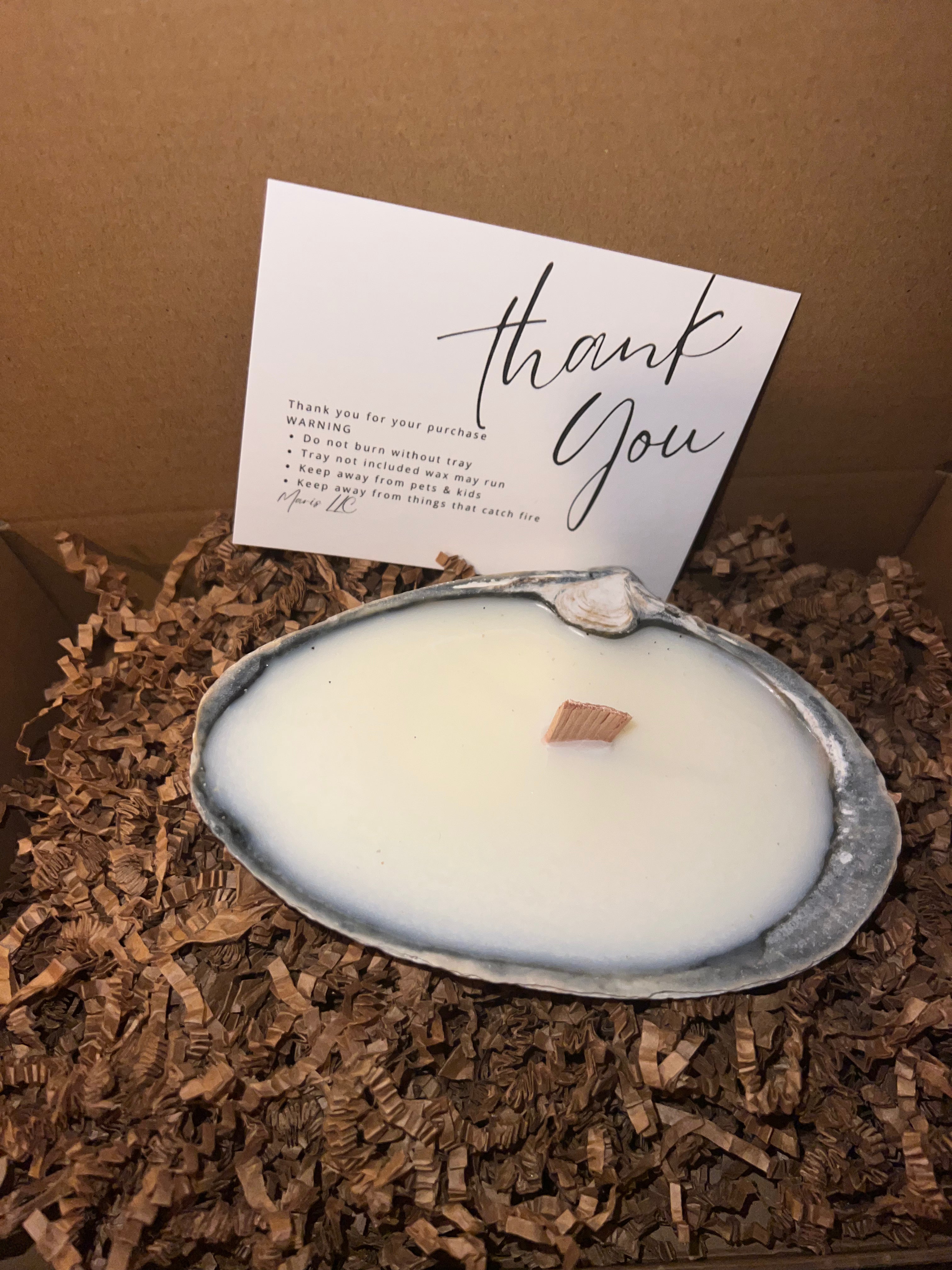 Limited edition candle in a dark, weathered quahog shell from December 2025 storm
