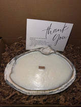 Limited edition candle in a dark, weathered quahog shell from December 2025 storm