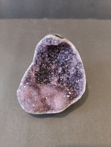 Polished Amethyst geode sculpture with Calcite crystal inclusions displaying purple and white crystalline formations