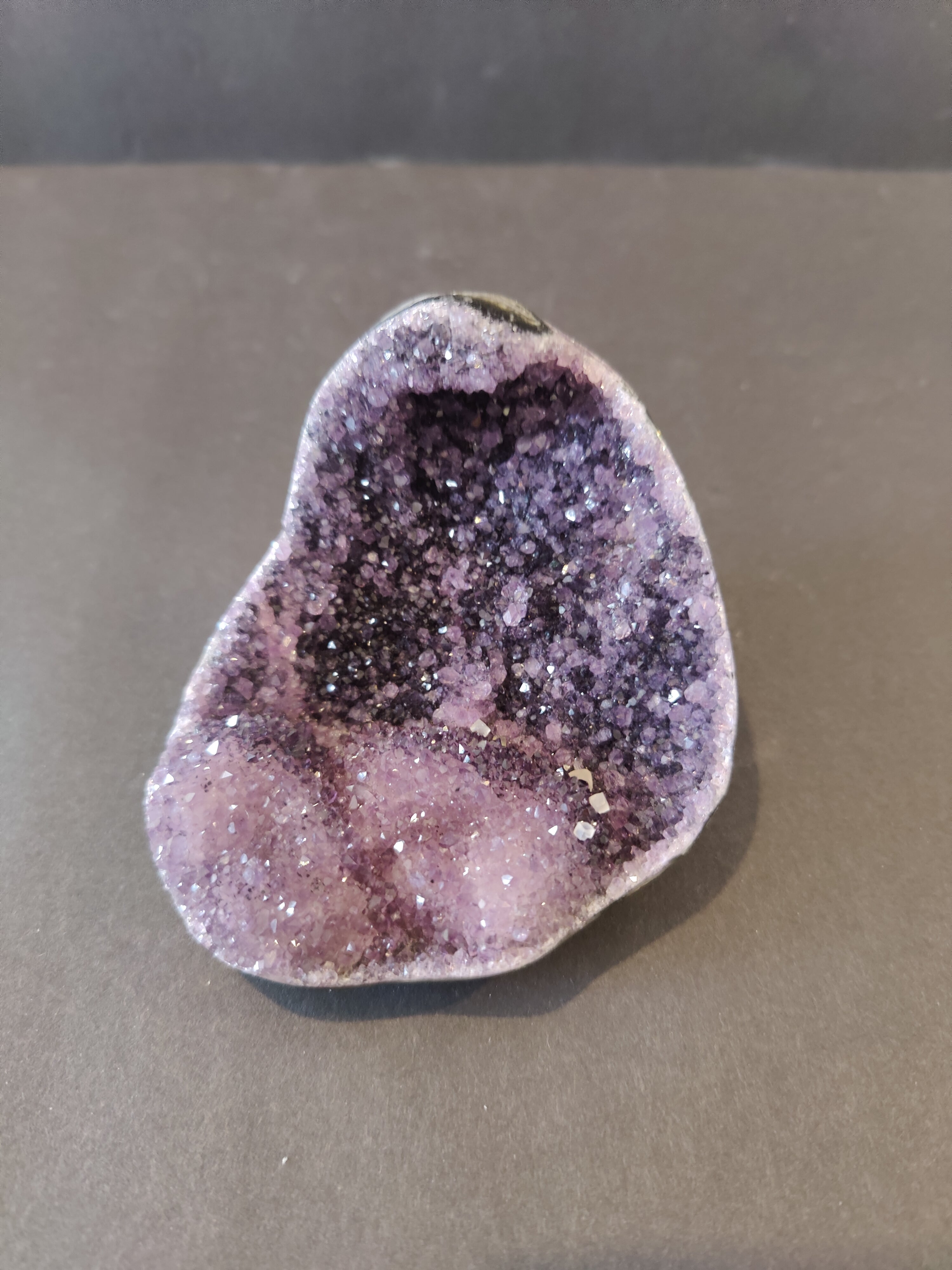 Polished Amethyst geode sculpture with Calcite crystal inclusions displaying purple and white crystalline formations