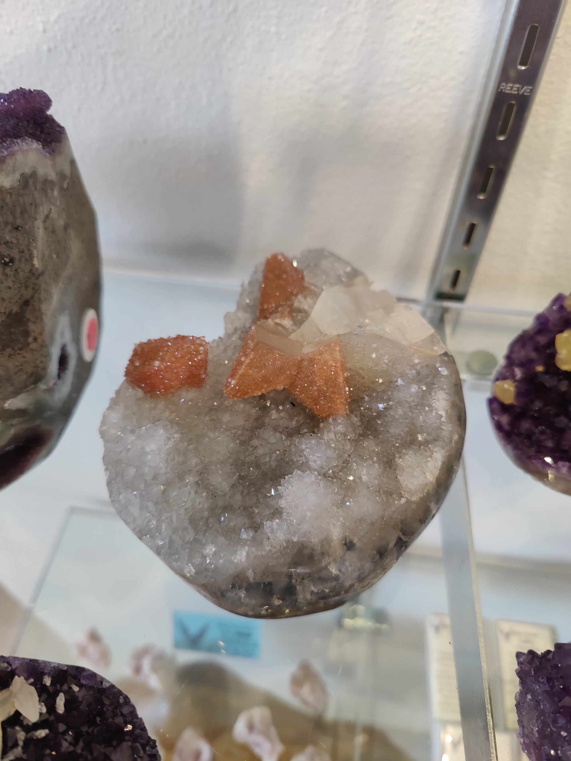 Polished clear quartz geode sculpture with visible quartz coated calcite inclusions against a dark background