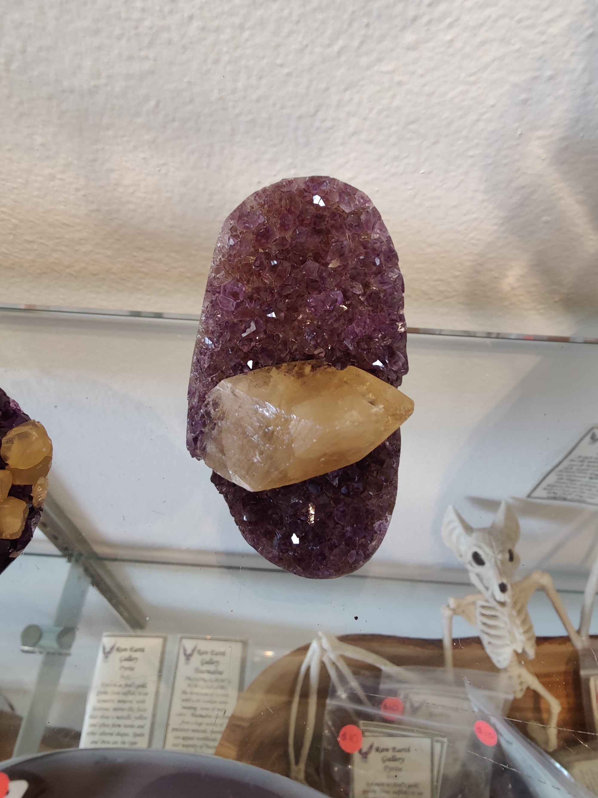 Amethyst geode sculpture with polished edges showing golden calcite crystal inclusion