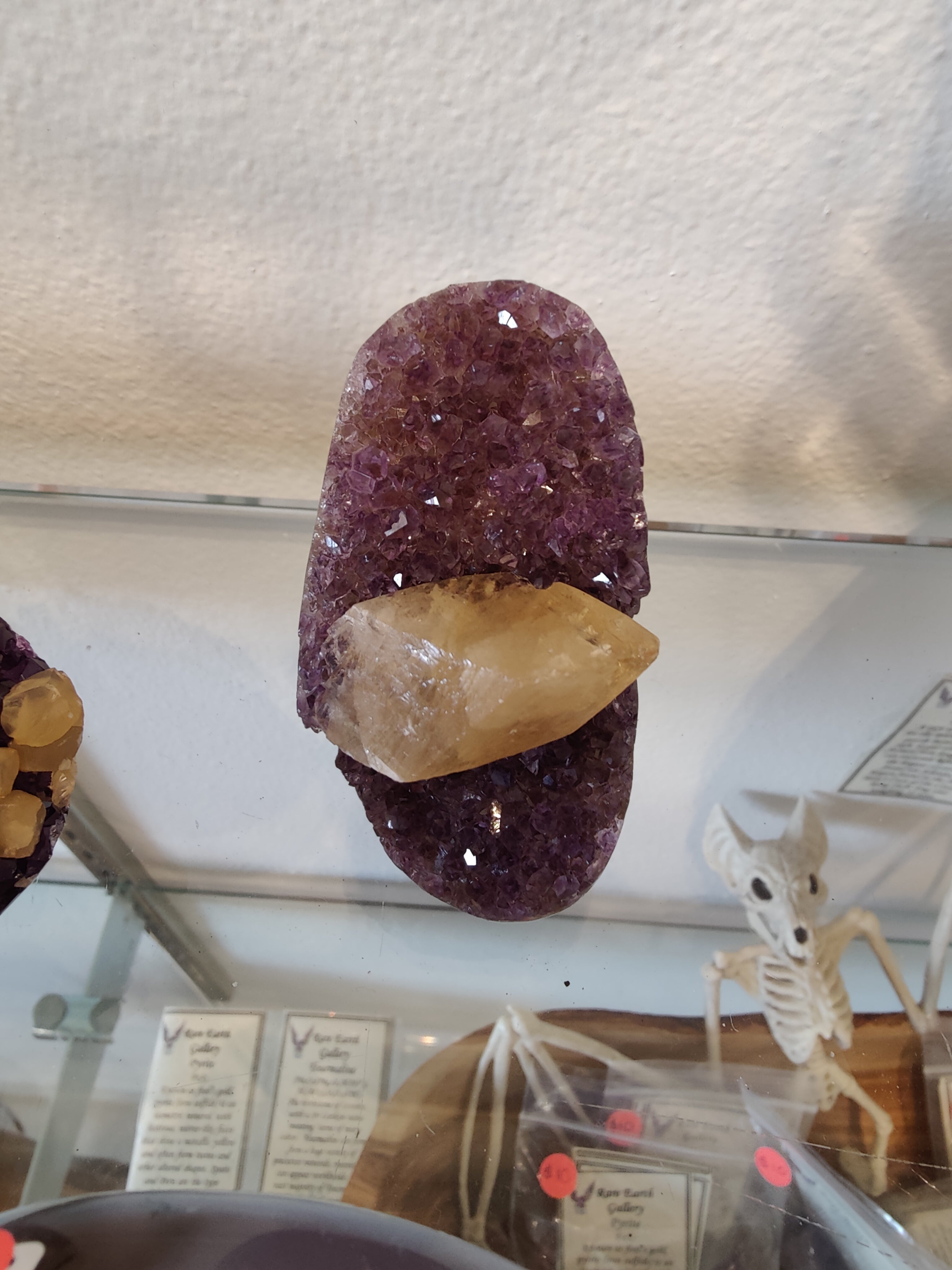 Amethyst geode sculpture with polished edges showing golden calcite crystal inclusion