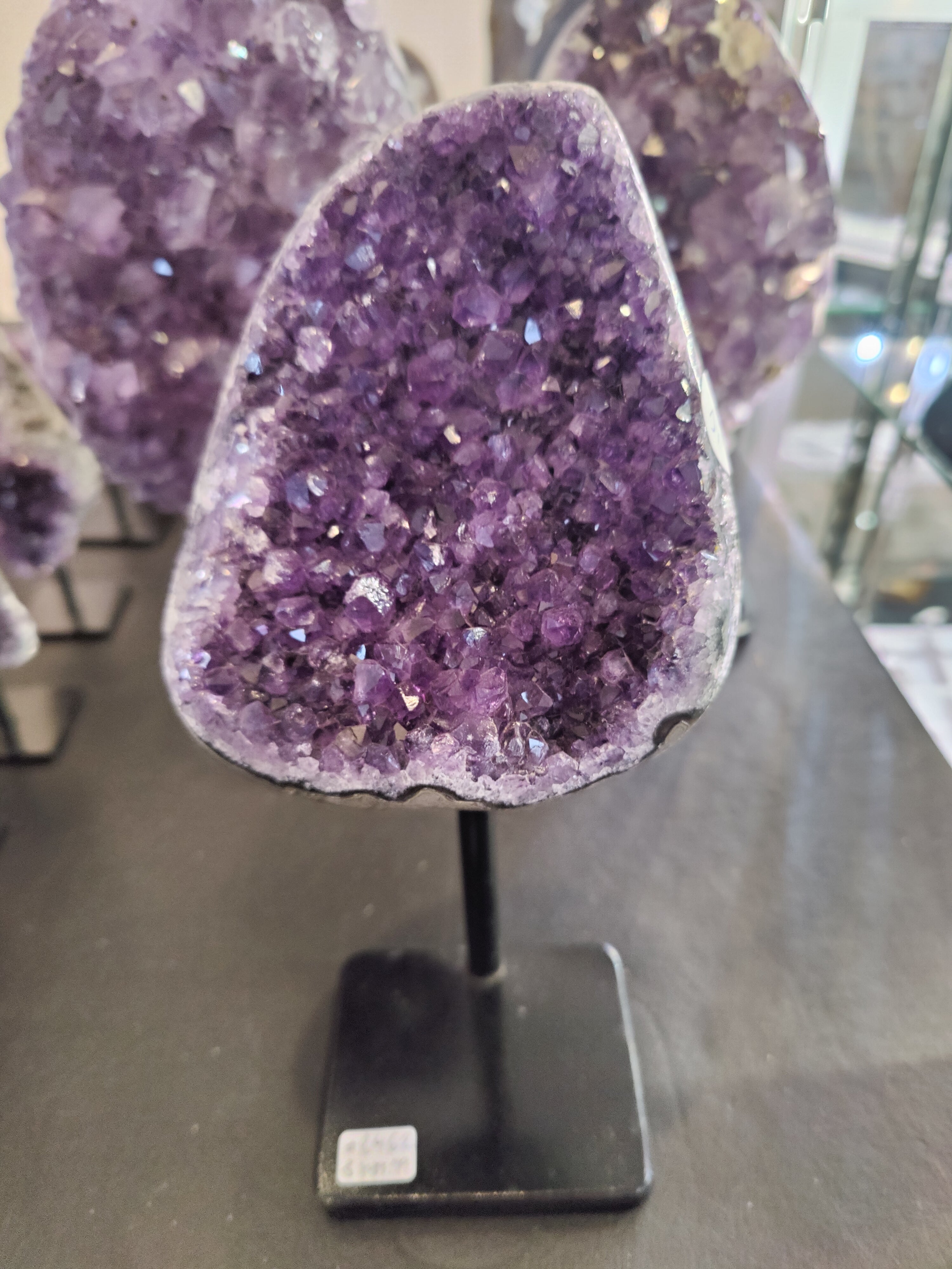 Amethyst crystal geode on a metal stand with faceted purple crystals visible