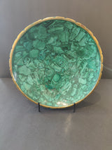Malachite decorative bowl with gold rim shown on wooden surface