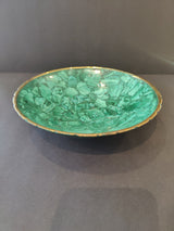 Round decorative bowl with a green malachite pattern and a thin gold rim, displayed against a dark gray background.