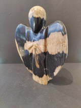 Sculpted angel figure carved from petrified wood with contrasting black and beige patches, showing smooth rounded wings and a head with no facial features.
