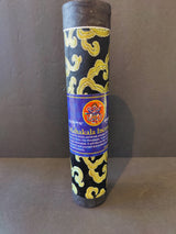 Cylindrical Tibetan incense stick bundle wrapped in black fabric with gold cloud-like patterns and a blue label featuring a red Mahakala symbol.