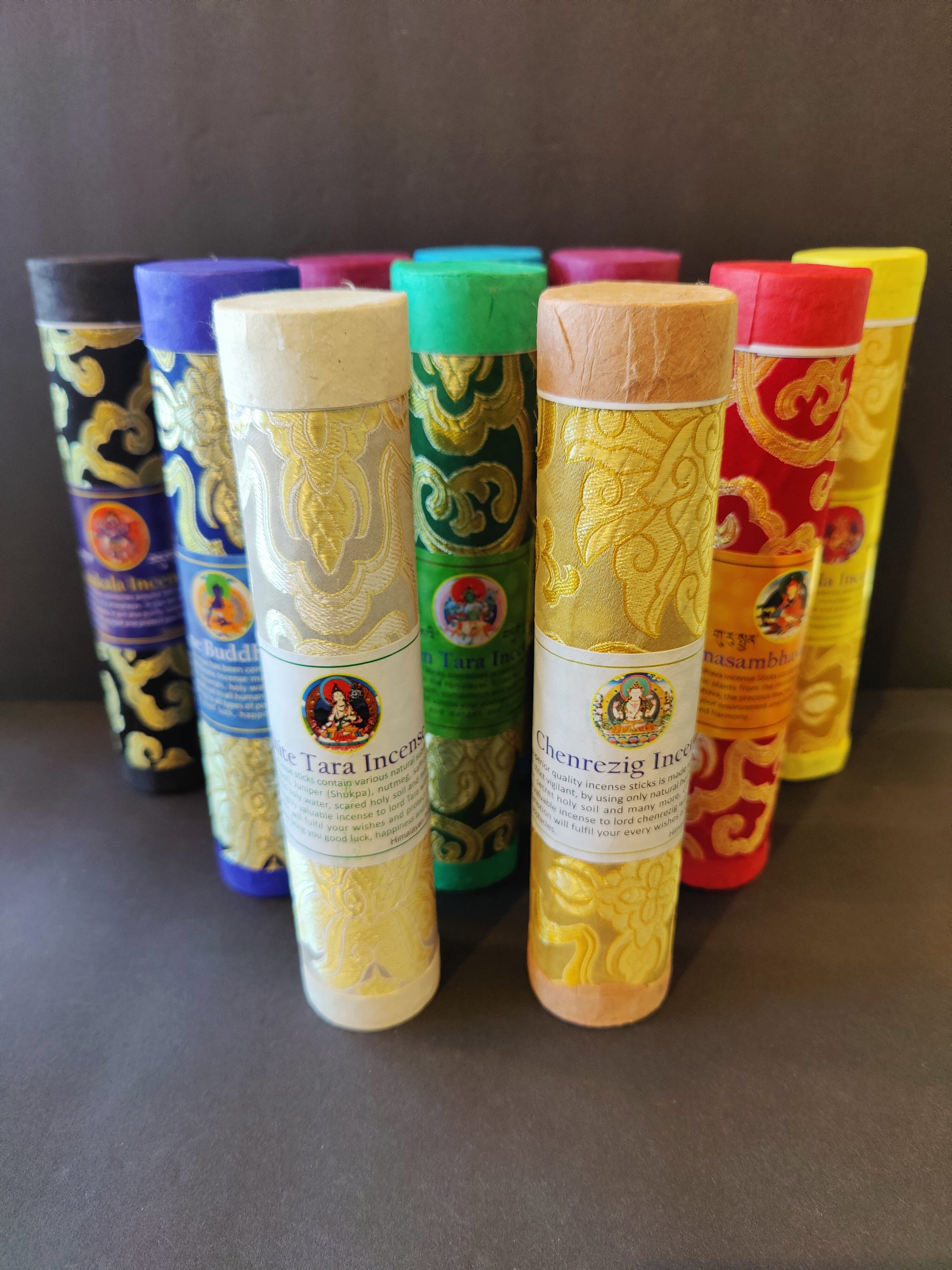 Bundles of Tibetan Handmade Incense sticks arranged on a flat surface with labels indicating various traditional scents.