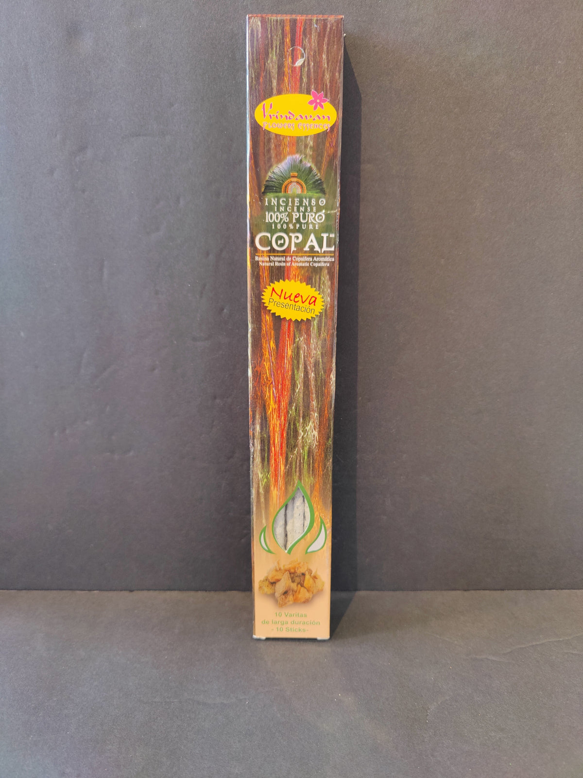 Tall rectangular package of Copal incense sticks with wood grain design and colorful labels on front against gray background