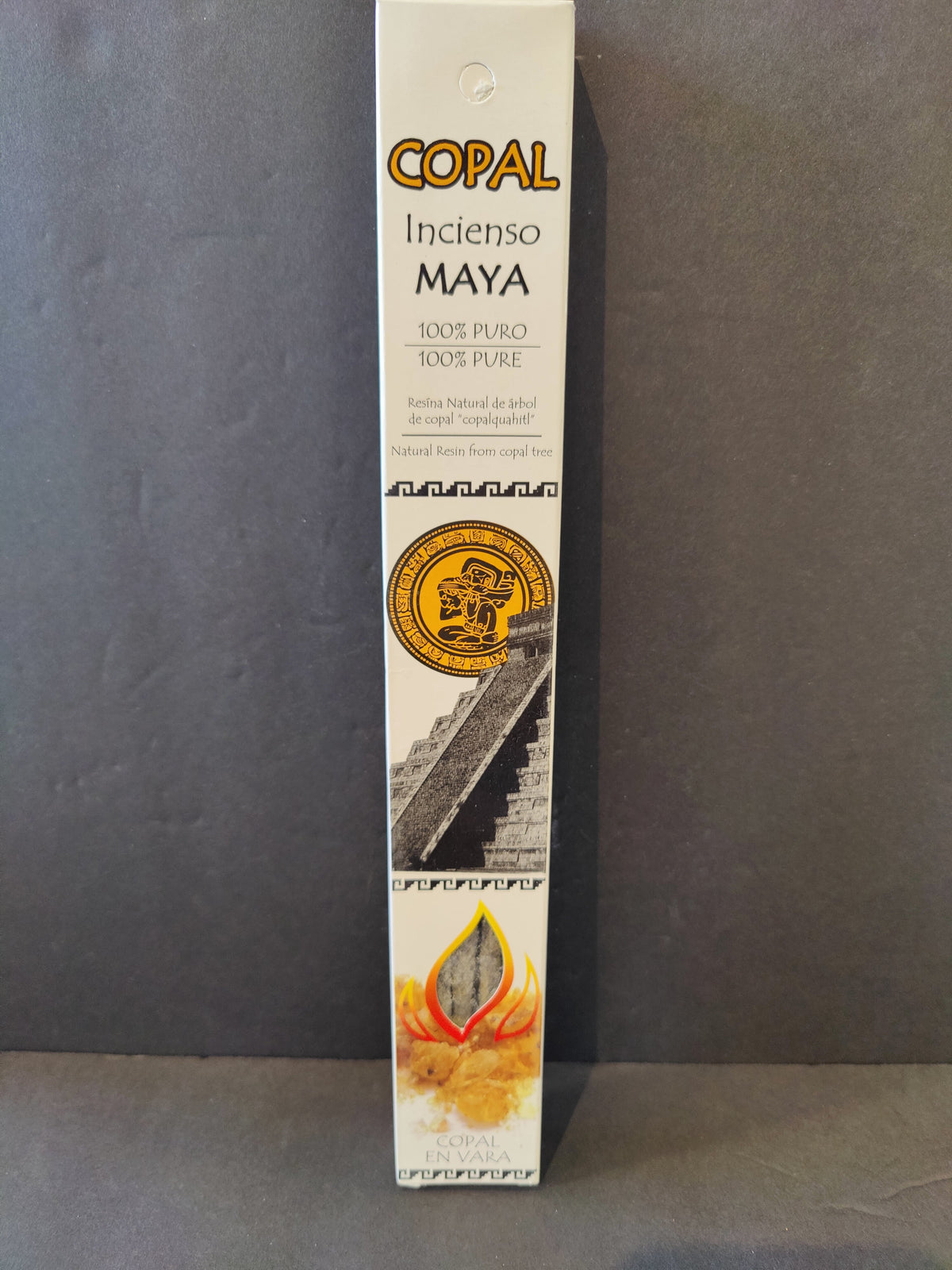 Tall white rectangular box of Copal Maya incense sticks with gold and black text, featuring a circular Mayan art emblem and a stepped pyramid image below it.