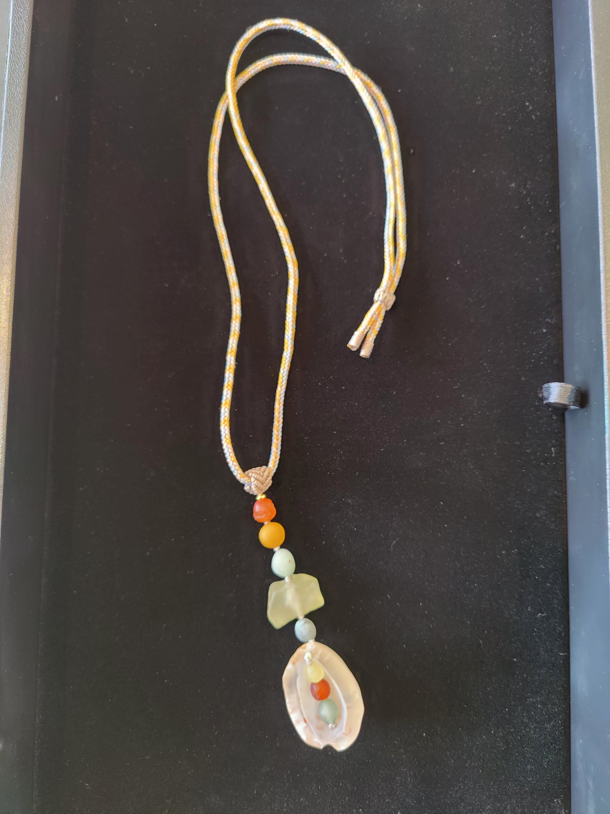 Gobi Desert Agate Necklace and Pendant on black cord displayed on beige fabric