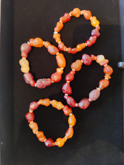 Gobi Desert Agate Beaded Bracelet with assorted colorful natural stones, laid on a neutral textile surface.