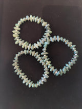 Three elastic bracelets made of irregular pale green and blue Gobi Desert Agate beads, arranged closely on a dark surface.