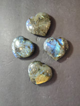 Labradorite carved and polished heart sculpture showing natural stone texture and colors